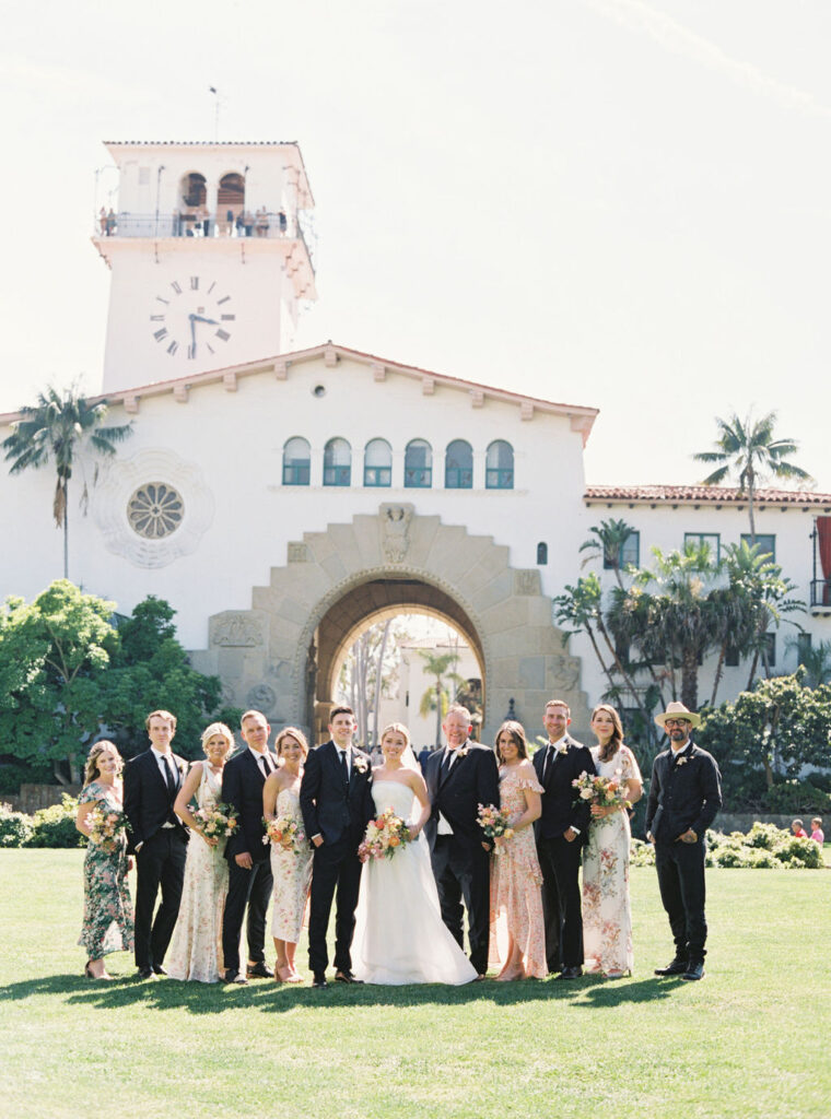 Wedding party in black suites and floral dresses at the Santa Barbara courthouse. 